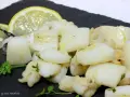 Sabrosa sepia al ajillo, troceada y salteada con ajo y perejil, servida con rodajas de limón.