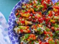 Mejillones a la vinagreta, cubiertos con una colorida mezcla de pimientos picados y cebolla.