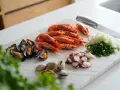 Ingredientes listos para un delicioso salpicón de marisco: gambas, mejillones, pulpo, almejas, cebolla y perejil picados.