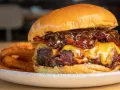 La mejor receta de hamburguesas caseras: jugosa carne, queso fundido, cebolla caramelizada y crujientes patatas fritas.