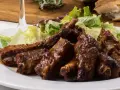 Costillas jugosas en freidora de aire, bañadas en salsa barbacoa y acompañadas de ensalada fresca. ¡Un manjar!