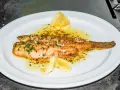 Delicioso lenguado a la meunière, bañado en mantequilla dorada, ajo y perejil, con gajos de limón.