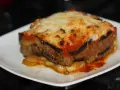 Porción de musaka casera con capas de berenjena, carne picada y salsa de tomate, gratinada con queso. ¡Una delicia de la musaka receta!