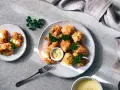 Crujientes trozos de coliflor rebozada, servidos con una cremosa salsa y decorados con perejil fresco. ¡Un aperitivo delicioso!