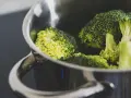 Brócoli fresco en una olla metálica, listo para cocción. El tiempo cocción brócoli olla normal es clave para su punto perfecto.