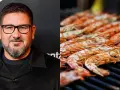 Hombre con gafas y barba junto a una parrilla llena de cigalas a la plancha, listas para ser degustadas.