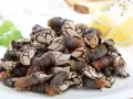 Montón de percebes frescos en un plato blanco, listos para cocinar. Se pueden congelar los percebes para disfrutarlos más tarde.