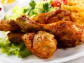 Crujientes muslos de pollo frito, acompañados de papas fritas, ensalada y tomate. ¡Un festín irresistible!