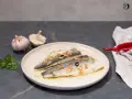 Dos filetes de lubina a la donostiarra, con láminas de ajo dorado, perejil picado y un toque de guindilla.