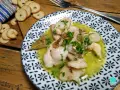 Plato de que son las cocochas de bacalao, tiernas y jugosas, en una salsa amarilla con perejil picado y galletas tostadas al lado.