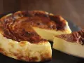 Tarta de queso al horno casera, dorada y cremosa, con una porción lista para disfrutar.