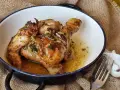 Sabroso pollo al ajillo dorado y jugoso, servido en una cazuela con su jugo y hierbas.