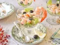 Delicioso cóctel de gambas servido en copa, con lechuga, aceitunas y un toque de limón. ¡Un clásico refrescante!