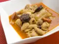 Un plato humeante de callos a la madrileña, con trozos de chorizo y morcilla en una rica salsa.