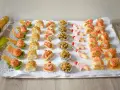 Bandeja con aperitivos navideños originales: mini tacos, bolitas de pistacho, brochetas de jamón y gambas, y rollitos de salmón.