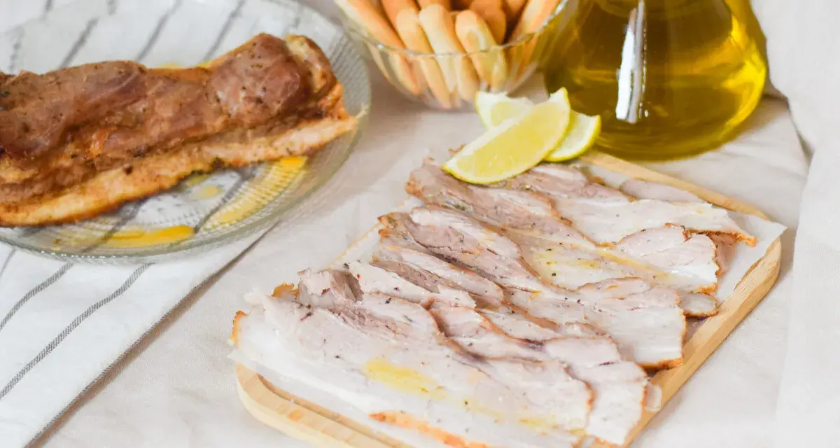 Chicharrón de Cádiz, lonchas de panceta crujiente, palitos de pan y aceite de oliva.