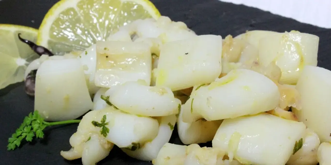 Sabrosa sepia al ajillo, troceada y salteada con ajo y perejil, servida con rodajas de limón.