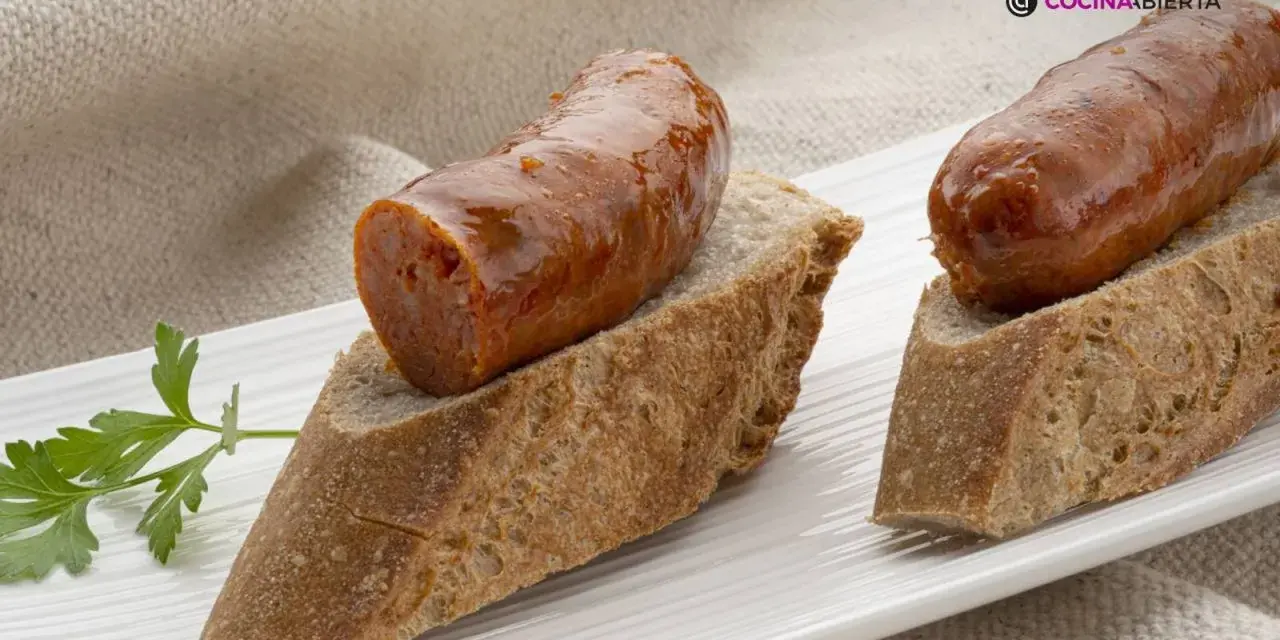Chorizo a la sidra jugoso sobre pan rústico, decorado con perejil fresco. Un bocado delicioso.