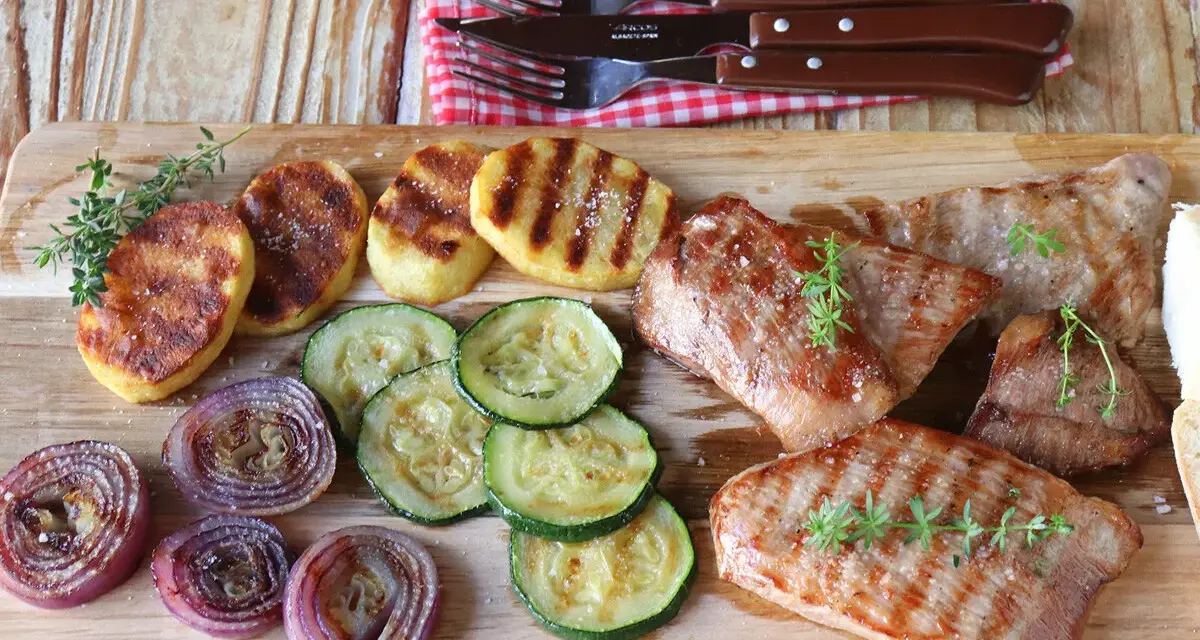 Delicioso escalope de ternera a la parrilla con patatas, calabacín y cebolla morada.