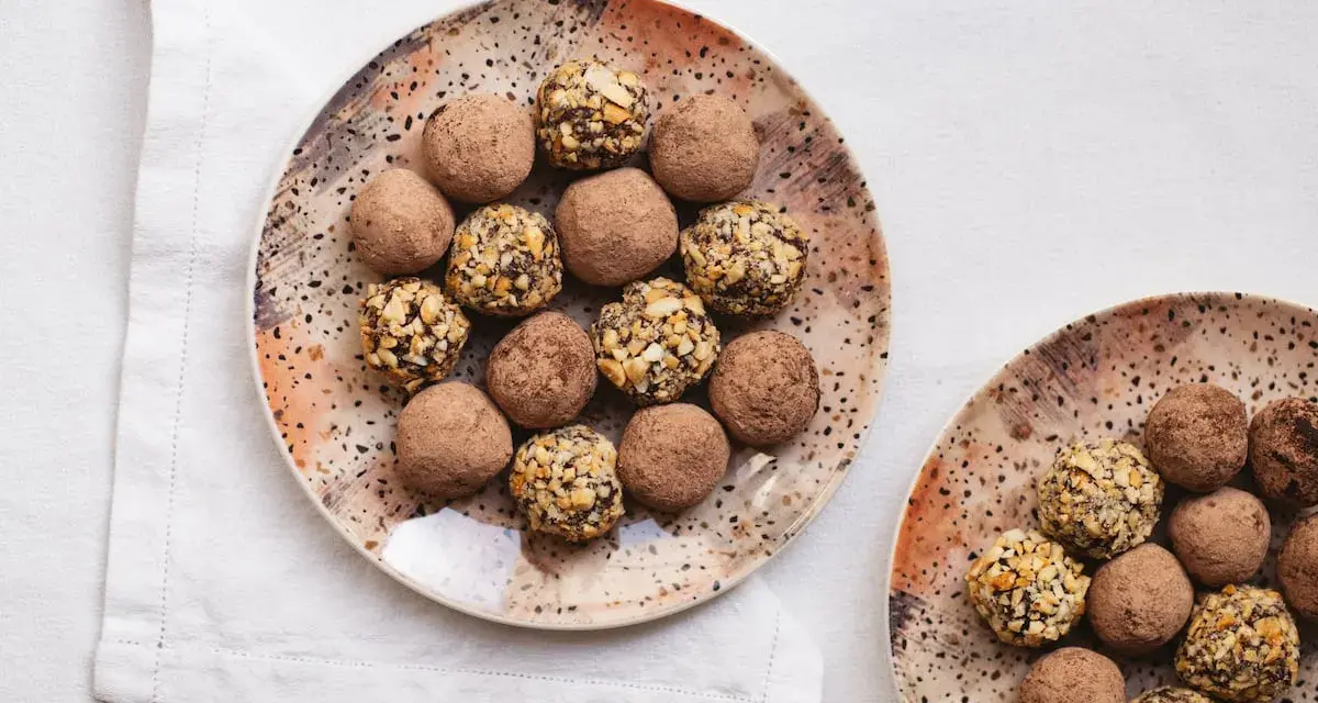 Dos platos con trufas de chocolate, algunas cubiertas de cacao y otras con trocitos de frutos secos. ¡Un placer para la vista y el paladar!
