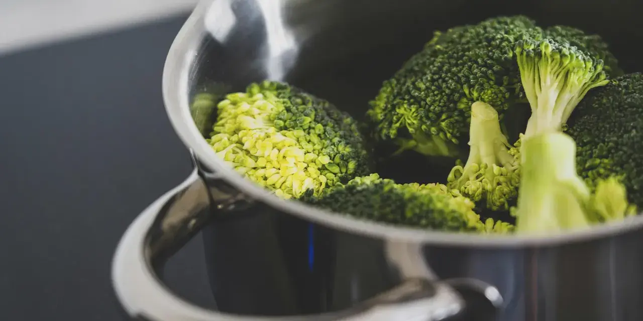 Brócoli fresco en una olla metálica, listo para cocción. El tiempo cocción brócoli olla normal es clave para su punto perfecto.