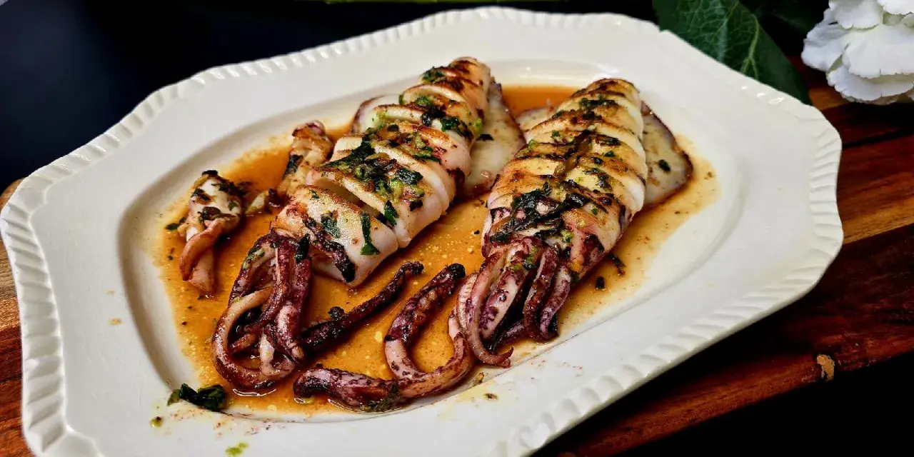Calamar a la plancha, jugoso y tierno, bañado en una salsa dorada con hierbas. ¡Perfecto para aprender como hacer calamar a la plancha!