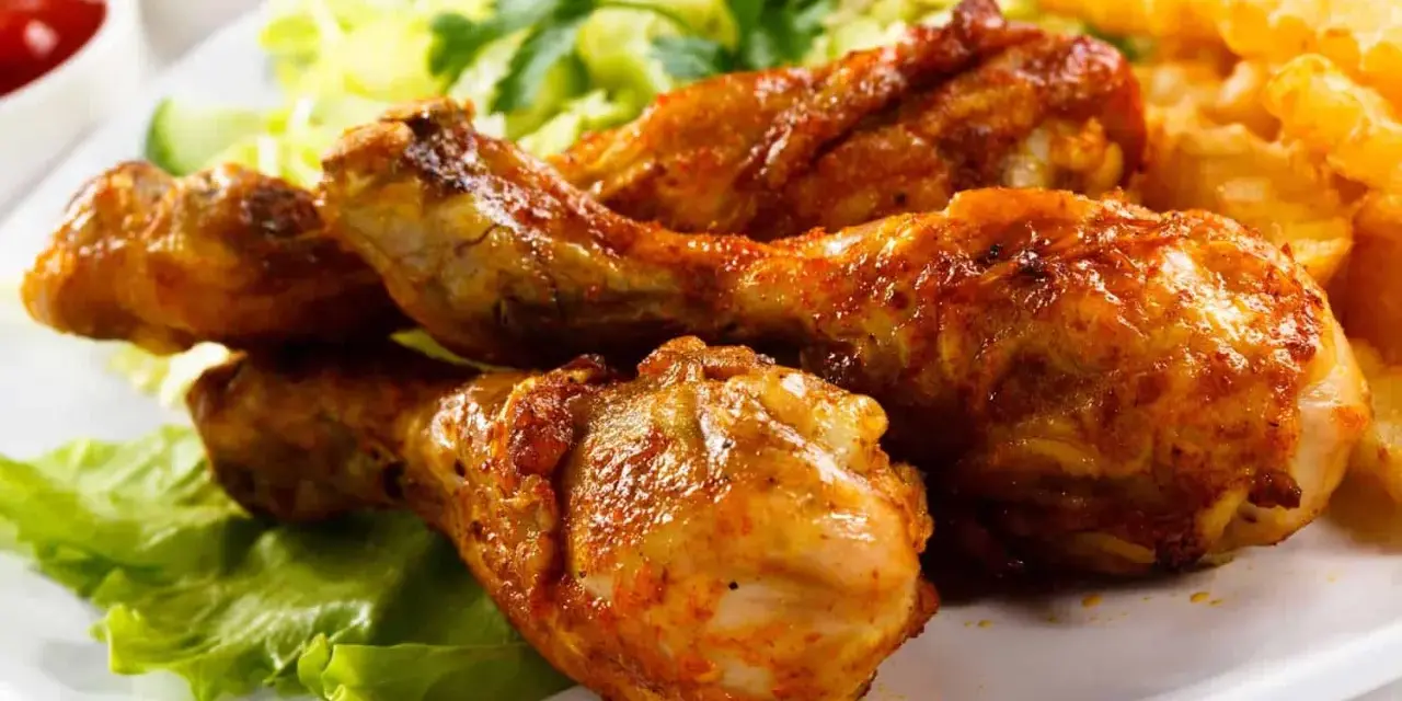 Crujientes muslos de pollo frito, acompañados de papas fritas, ensalada y tomate. ¡Un festín irresistible!