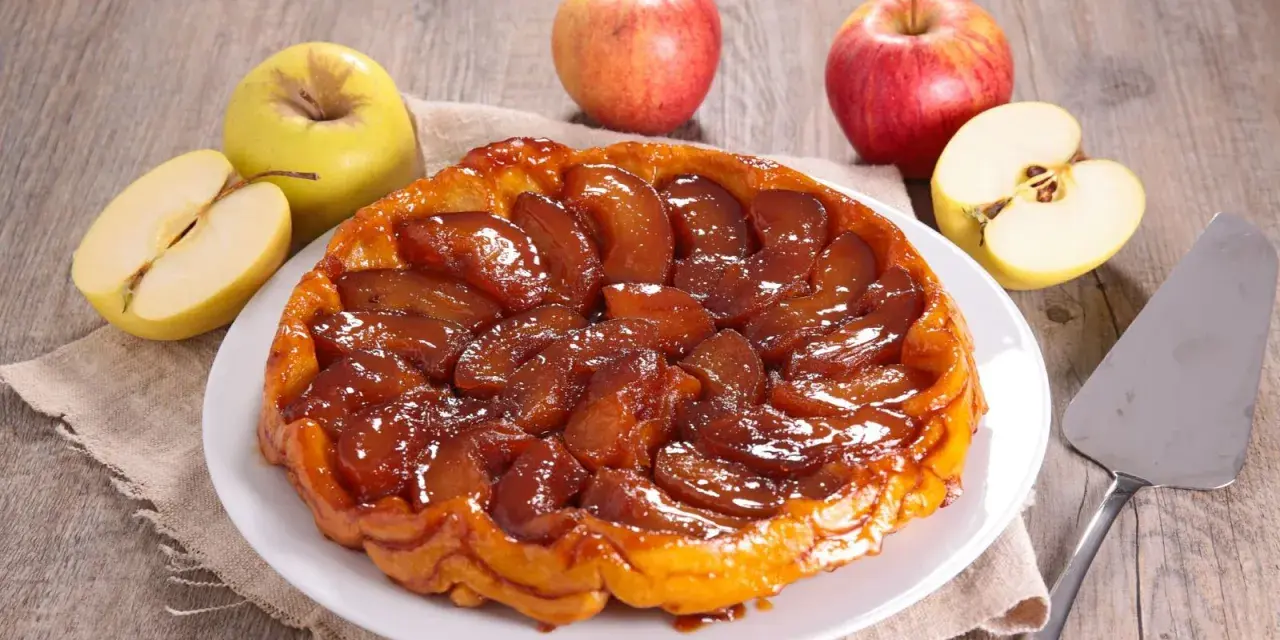 Deliciosa tarta tatin dorada y caramelizada, rodeada de manzanas frescas. Perfecta para compartir.