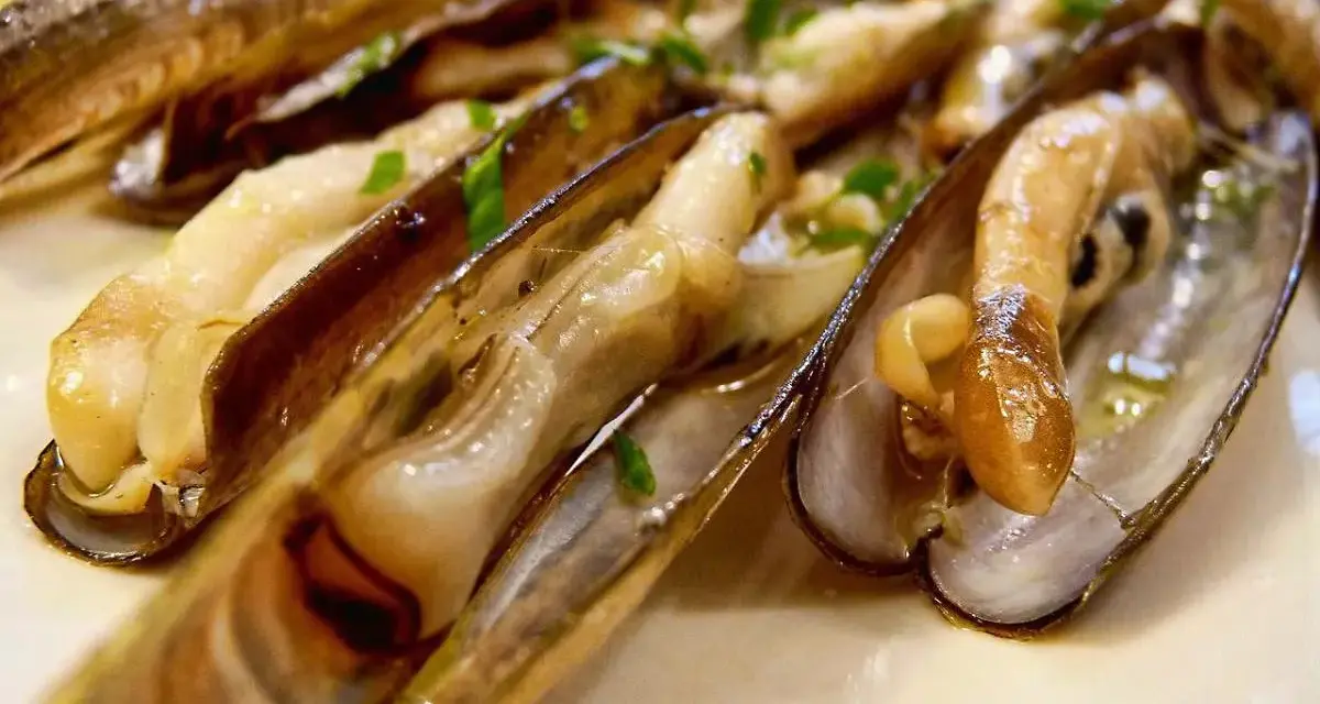 Navajas cocinadas en su jugo, con perejil picado y una rodaja de limón. ¡Estas navajas se pueden congelar para disfrutarlas más tarde!