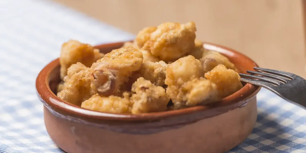 Tazón de fritura de pescado crujiente, listo para disfrutar con un tenedor.