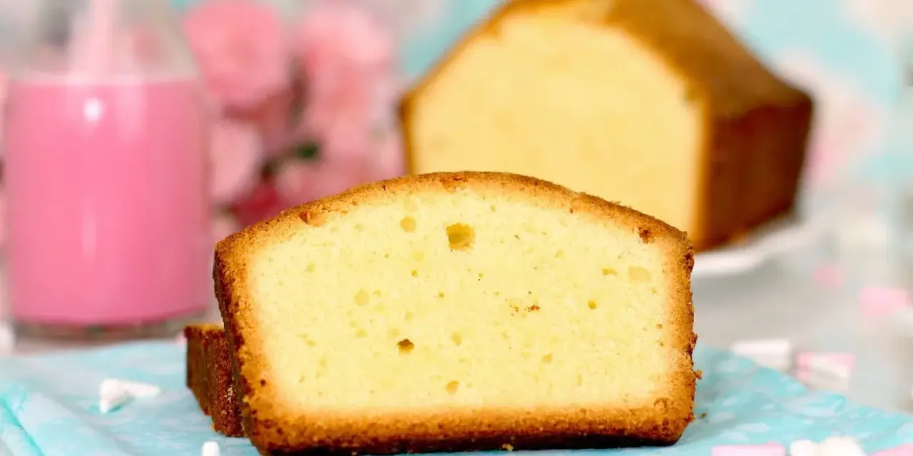 Rebanadas de bizcocho esponjoso, perfecto para tu próxima receta. Acompañado de un batido rosa y flores.