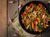 Sabroso wok de pollo con pimientos de colores y judías verdes, espolvoreado con semillas de sésamo y cebolleta.