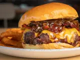 La mejor receta de hamburguesas caseras: jugosa carne, queso fundido, cebolla caramelizada y crujientes patatas fritas.