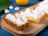 Tarta de limón con merengue suizo tostado, decorada con picos dorados.
