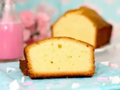 Rebanadas de bizcocho esponjoso, perfecto para tu próxima receta. Acompañado de un batido rosa y flores.