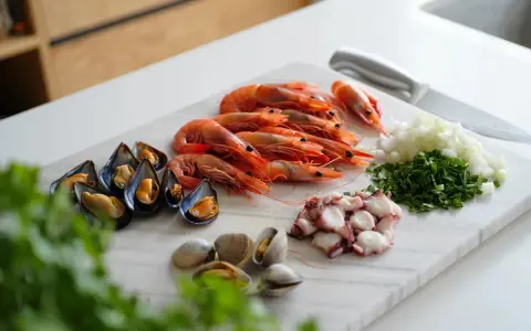 Ingredientes listos para un delicioso salpicón de marisco: gambas, mejillones, pulpo, almejas, cebolla y perejil picados.