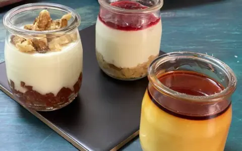 Tres postres en frascos: uno con nueces, otro con mermelada y galleta, y un flan de queso con caramelo.