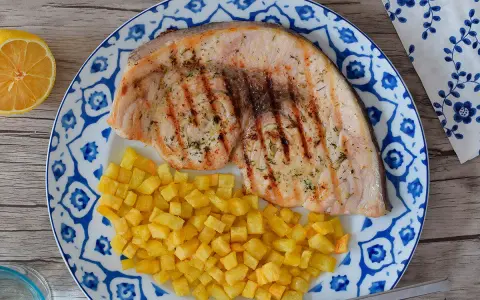 Pez espada filete a la parrilla con patatas fritas crujientes y limón. Un plato delicioso y saludable.