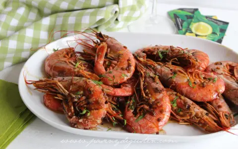 Plato de gambones al ajillo, jugosos y con perejil picado, listos para disfrutar.