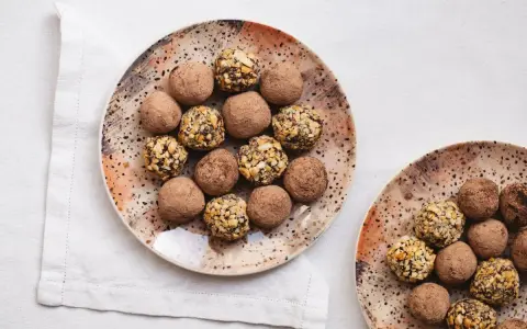 Dos platos con trufas de chocolate, algunas cubiertas de cacao y otras con trocitos de frutos secos. ¡Un placer para la vista y el paladar!