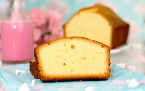 Rebanadas de bizcocho esponjoso, perfecto para tu próxima receta. Acompañado de un batido rosa y flores.