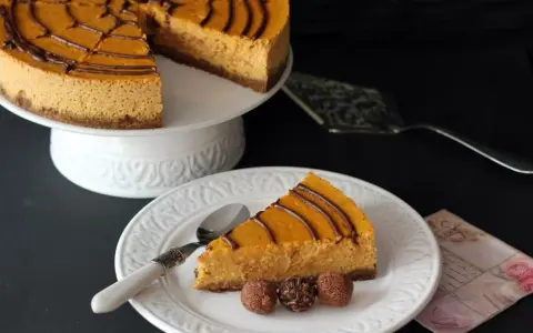 Deliciosa tarta de queso de calabaza con un toque de chocolate, servida en un plato blanco con tres trufas.