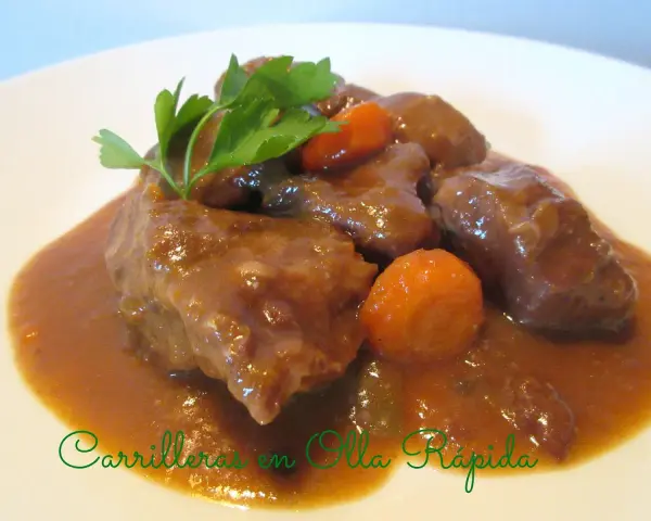 Carrilleras de cerdo en olla express, tiernas y jugosas, con zanahorias y perejil. ¡Un plato rápido y delicioso!