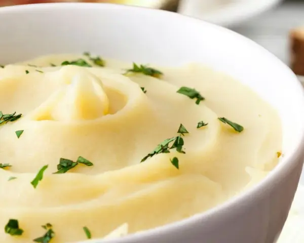Cremoso parmentier de patata, adornado con perejil fresco, listo para ser disfrutado.