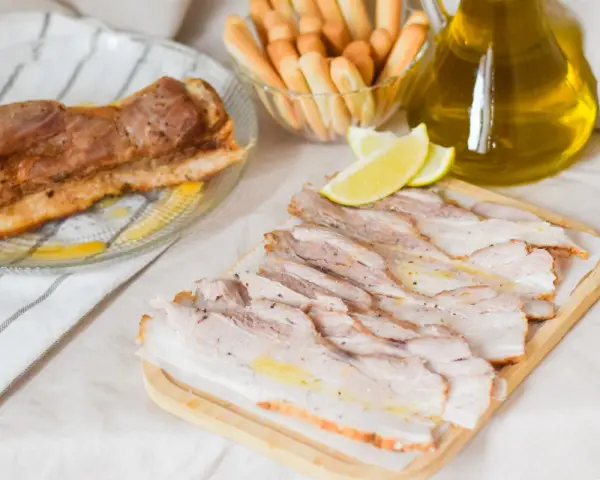 Chicharrón de Cádiz, lonchas de panceta crujiente, palitos de pan y aceite de oliva.