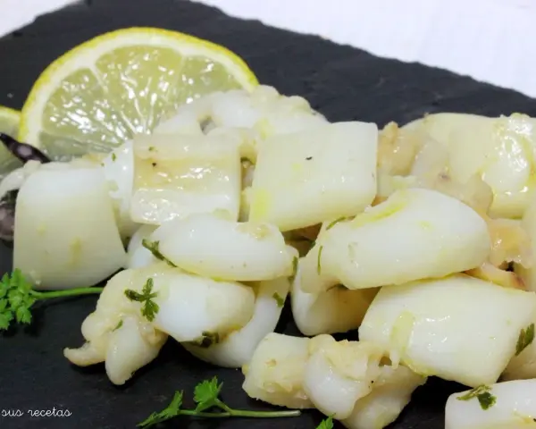 Sabrosa sepia al ajillo, troceada y salteada con ajo y perejil, servida con rodajas de limón.