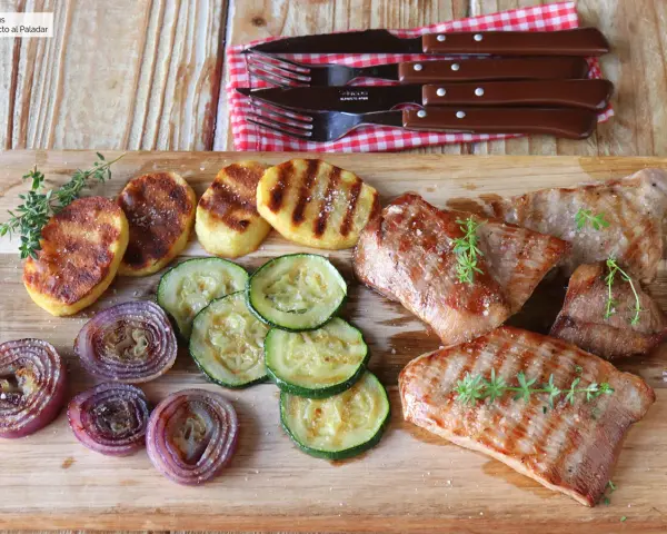 Delicioso escalope de ternera a la parrilla con patatas, calabacín y cebolla morada.