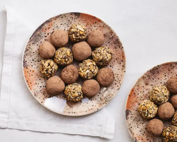 Dos platos con trufas de chocolate, algunas cubiertas de cacao y otras con trocitos de frutos secos. ¡Un placer para la vista y el paladar!