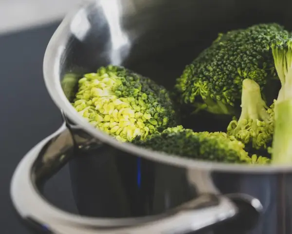 Brócoli fresco en una olla metálica, listo para cocción. El tiempo cocción brócoli olla normal es clave para su punto perfecto.