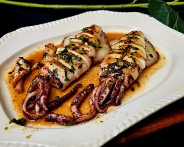 Calamar a la plancha, jugoso y tierno, bañado en una salsa dorada con hierbas. ¡Perfecto para aprender como hacer calamar a la plancha!